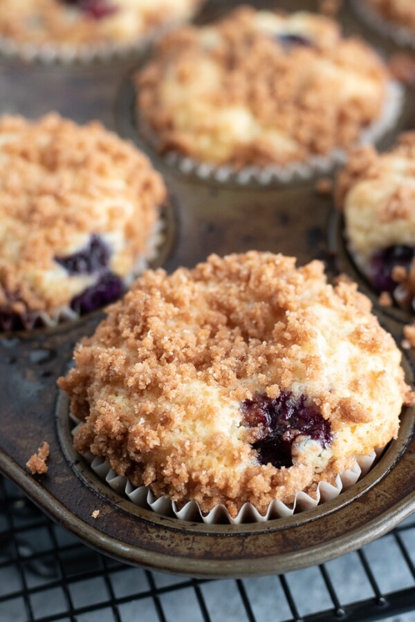 blueberry crumb muffins in a muffin pan
