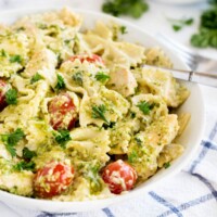 pasta with tomatoes and pesto in a white bowl