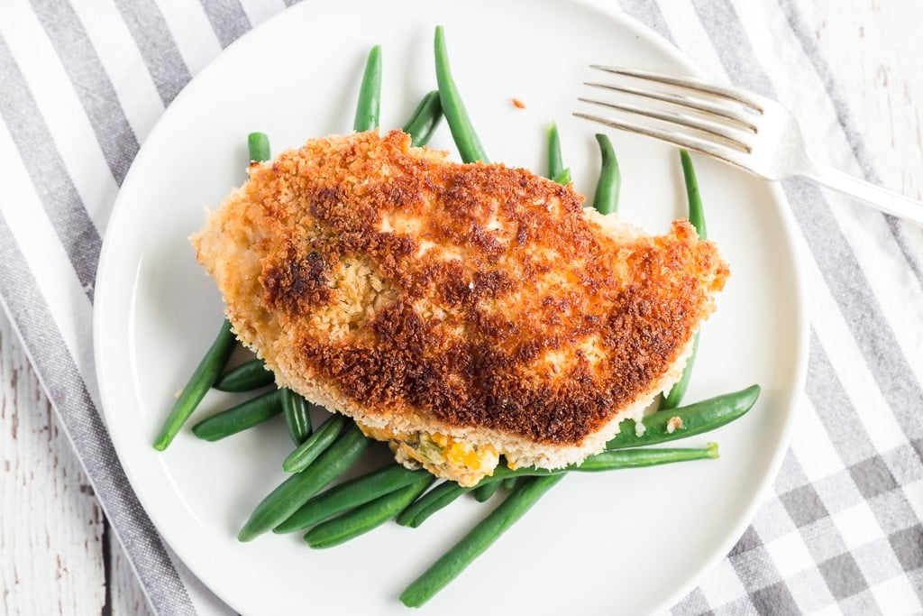 jalapeno popper chicken on top of green beans and a fork