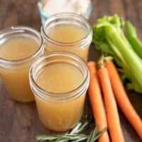 chicken stock in mason jars with carrots, celery, rosemary