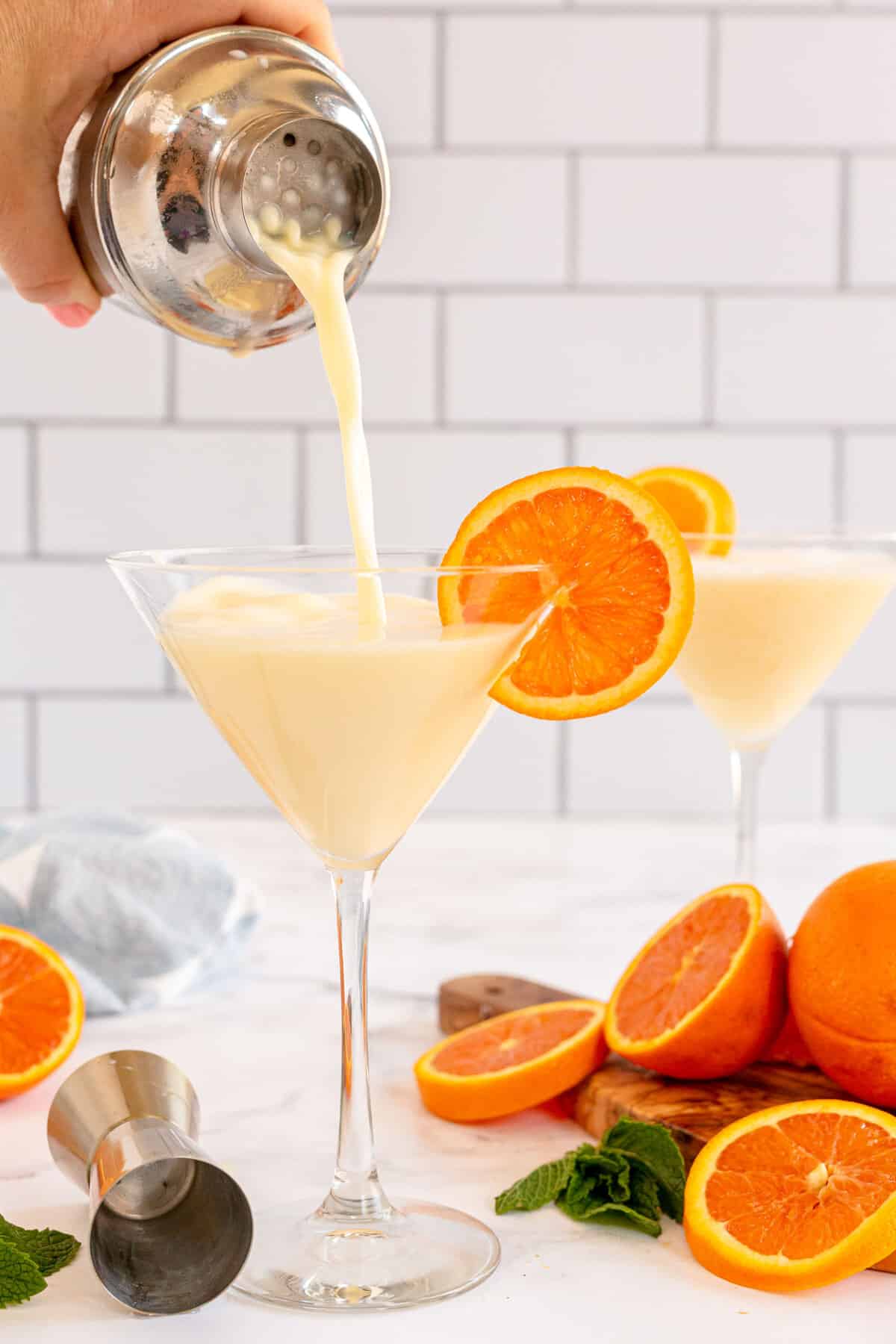 Orange martini being poured into a glass
