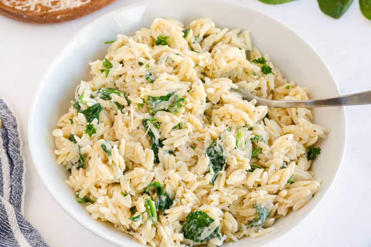 Spinach orzo in a white bowl 