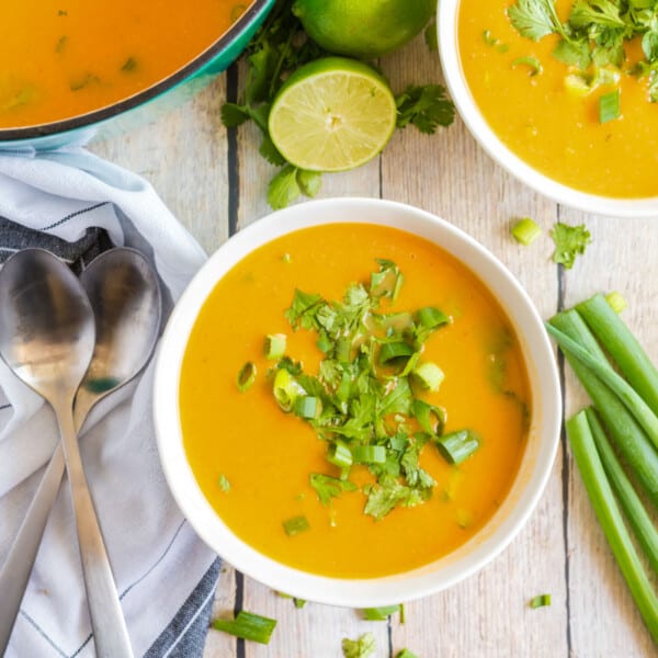 Sweet Potato Soup in white bowl with greens