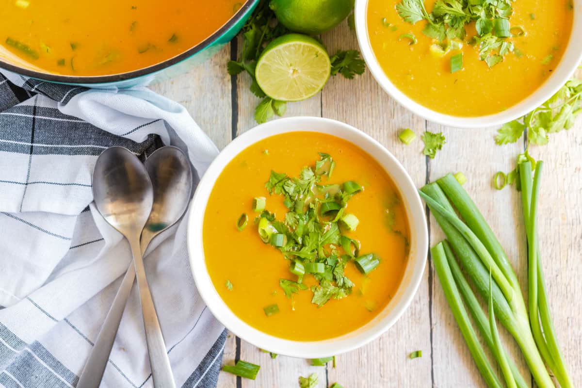 Sweet Potato Soup in white bowl with greens