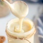 homemade sweetened condensed milk on a spoon.