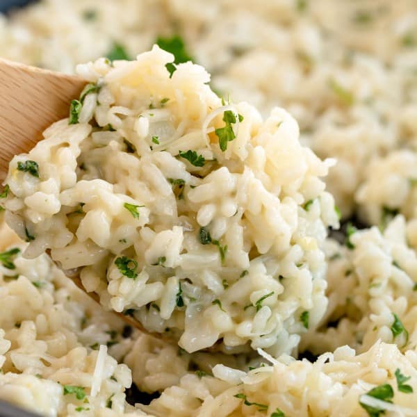 risotto recipe in a skillet with a wooden spoon