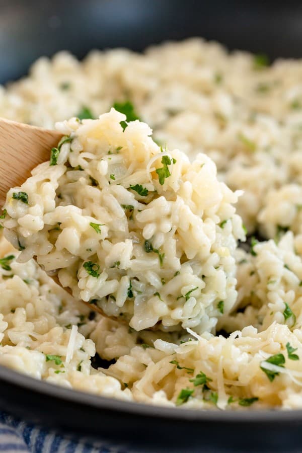 risotto recipe in a skillet with a wooden spoon