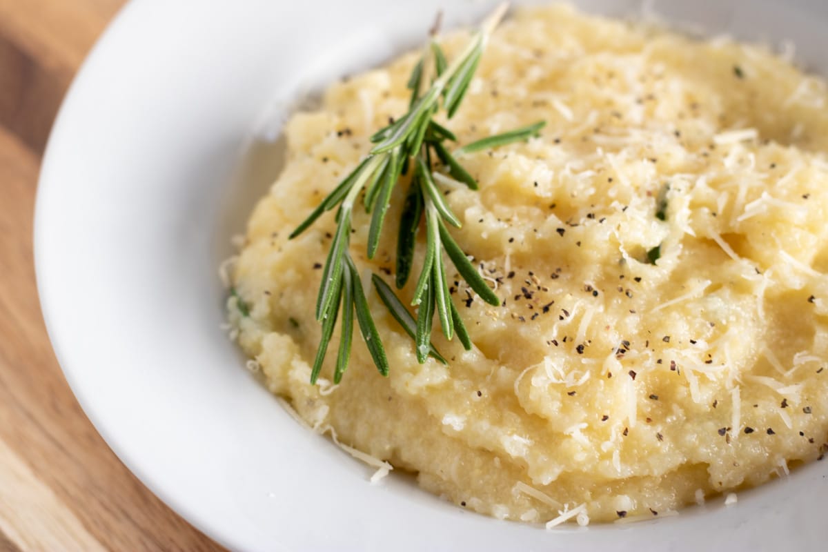 parmesan polenta with rosemary in a white bowl