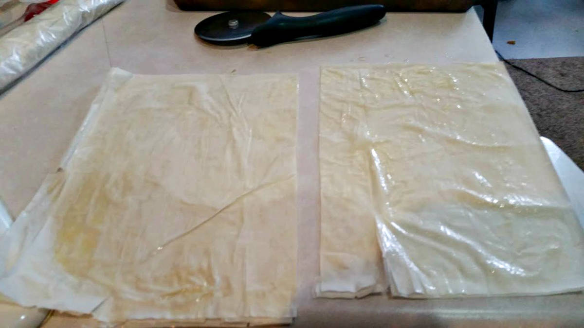 two sheets of phyllo dough on a counter top.