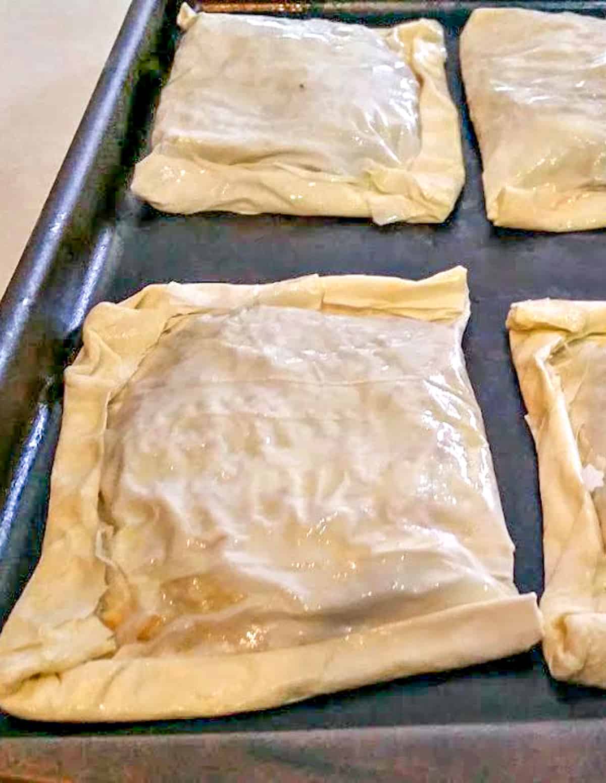 unbaked phyllo meat pie on a baking sheet.