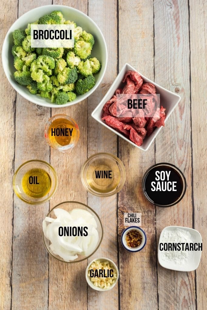 beef and broccoli ingredients laid out on a wooden board, labeled