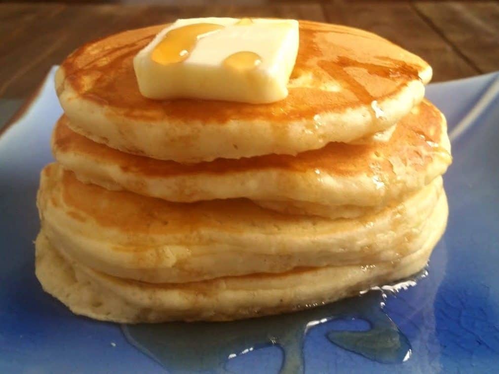 stack of homemade pancakes with butter and syrup
