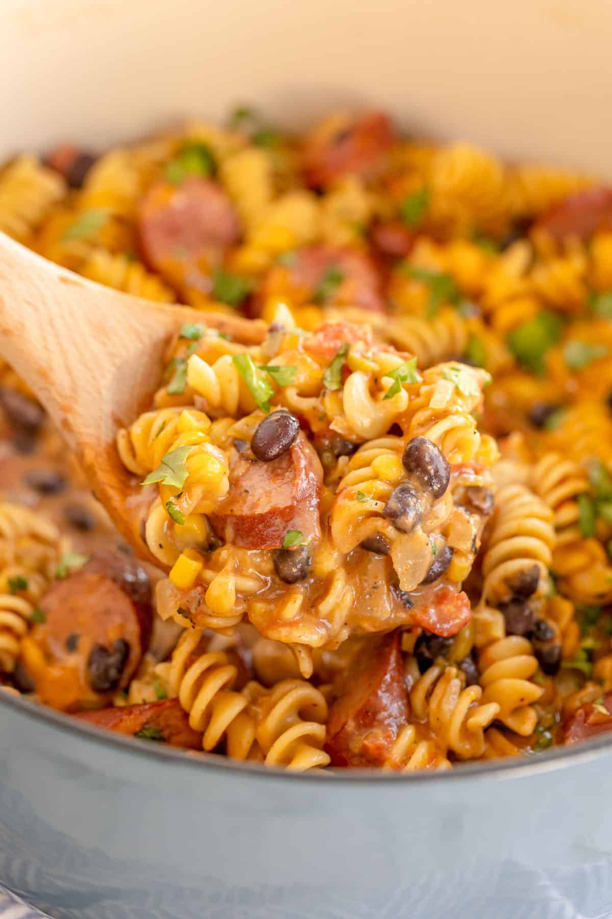 Mexican pasta in a dutch oven with a wooden spoon.