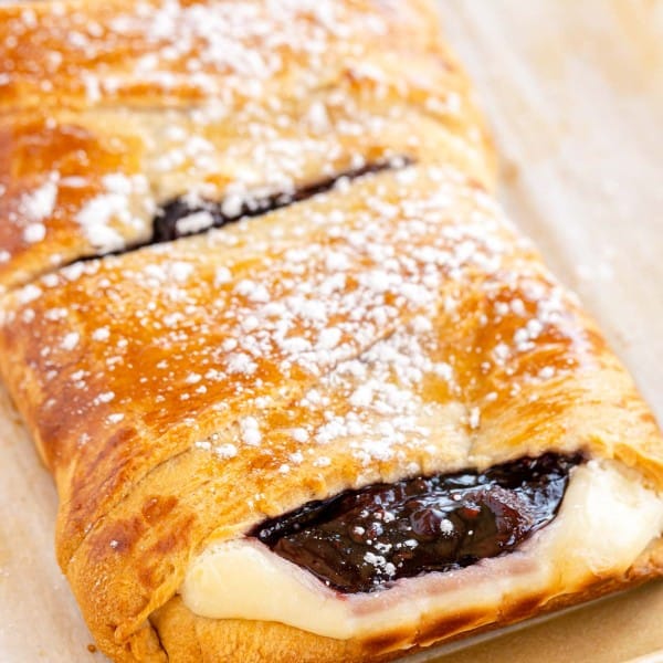 A raspberry-filled danish topped with powdered sugar.