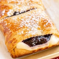 A raspberry-filled danish topped with powdered sugar.