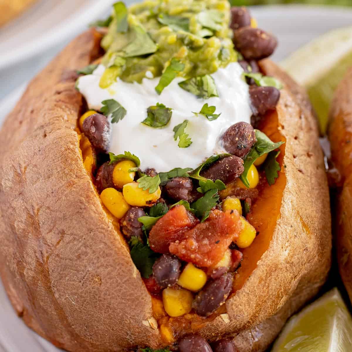 baked sweet potato with black bean salad on a plate.