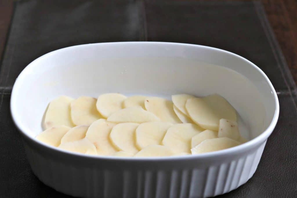 potatoes layered in a baking dish to make scalloped potatoes