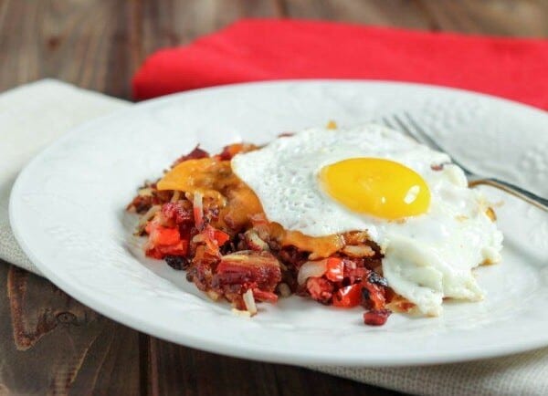Corned beef hash with a fried egg on a white plate.