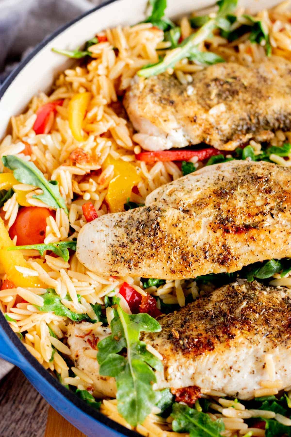 chicken and orzo in a blue skillet