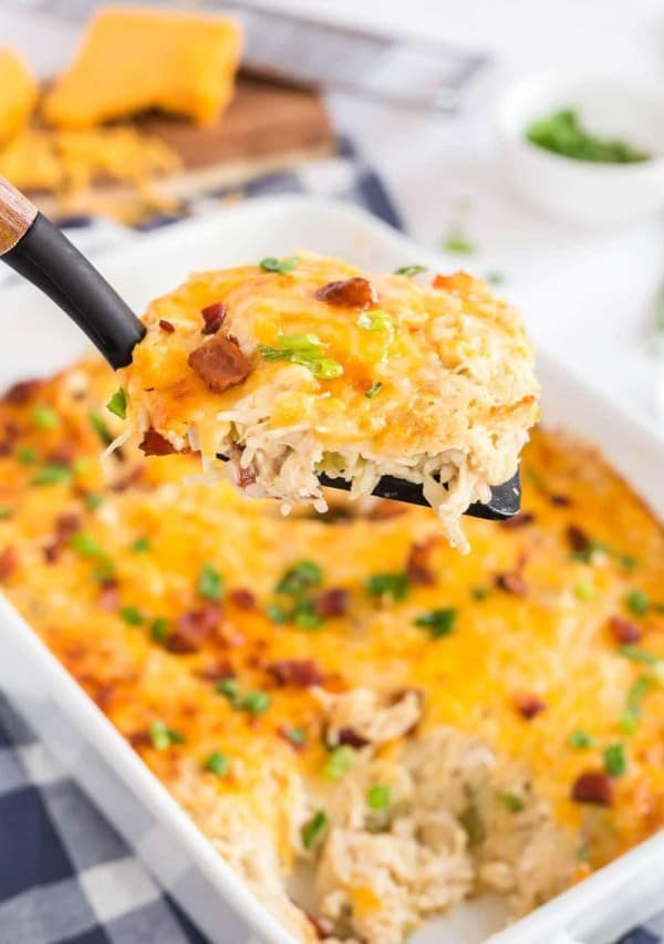 A close up a spoon with chicken and rice casserole on it