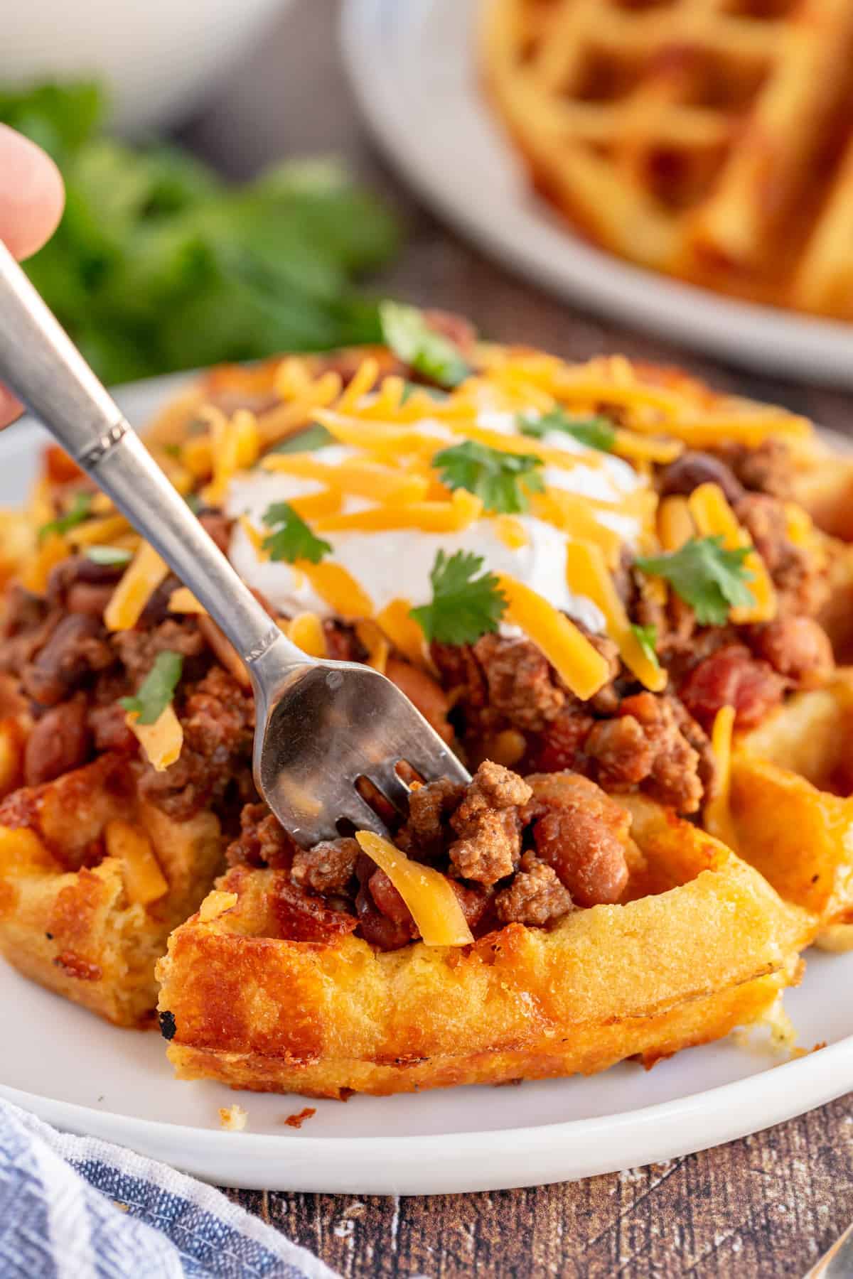 cornbread waffle with chili on top and a fork