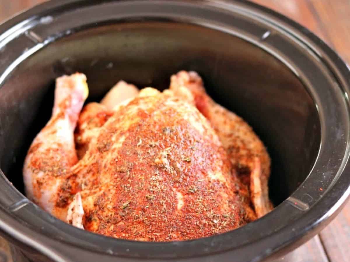 whole chicken in a crockpot ready to cook