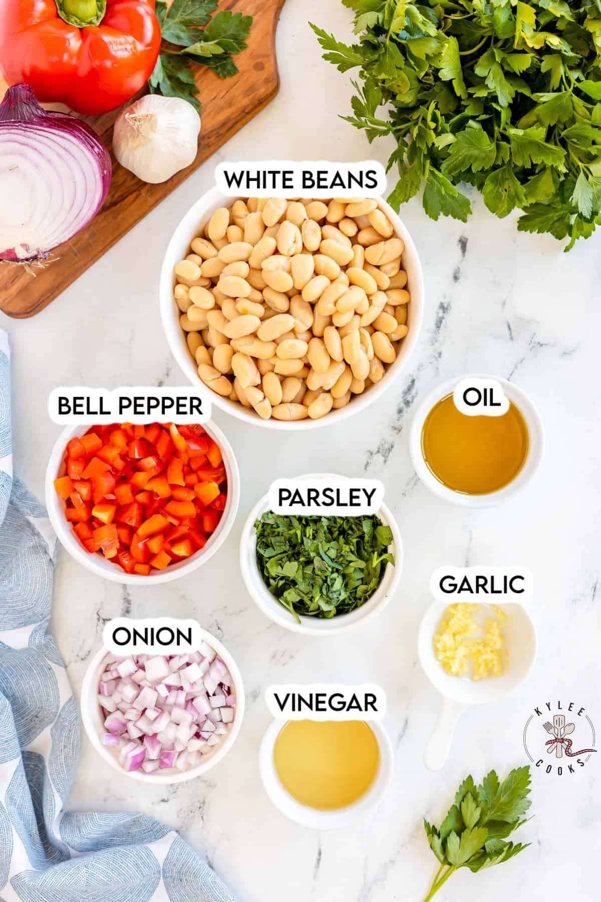ingredients to make white bean salad laid out and labeled.