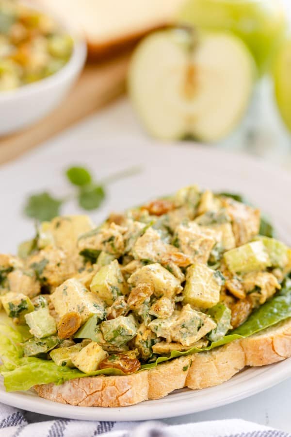 curried chicken salad with lettuce on a slice of bread.
