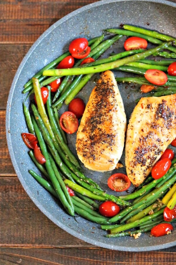 chicken with green beans and tomatoes in a skillet