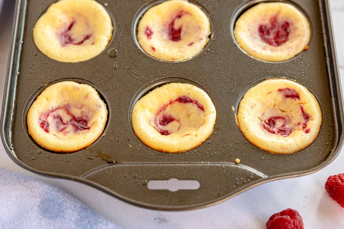 Raspberry lemon cheesecakes in a baking tin.