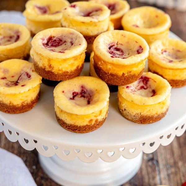 mini lemon cheesecakes with berry swirl on a cake stand