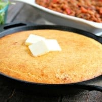 cast iron skillet of cornbread with butter on top