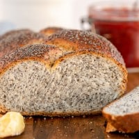 braided bread with poppy seeds sliced with butter