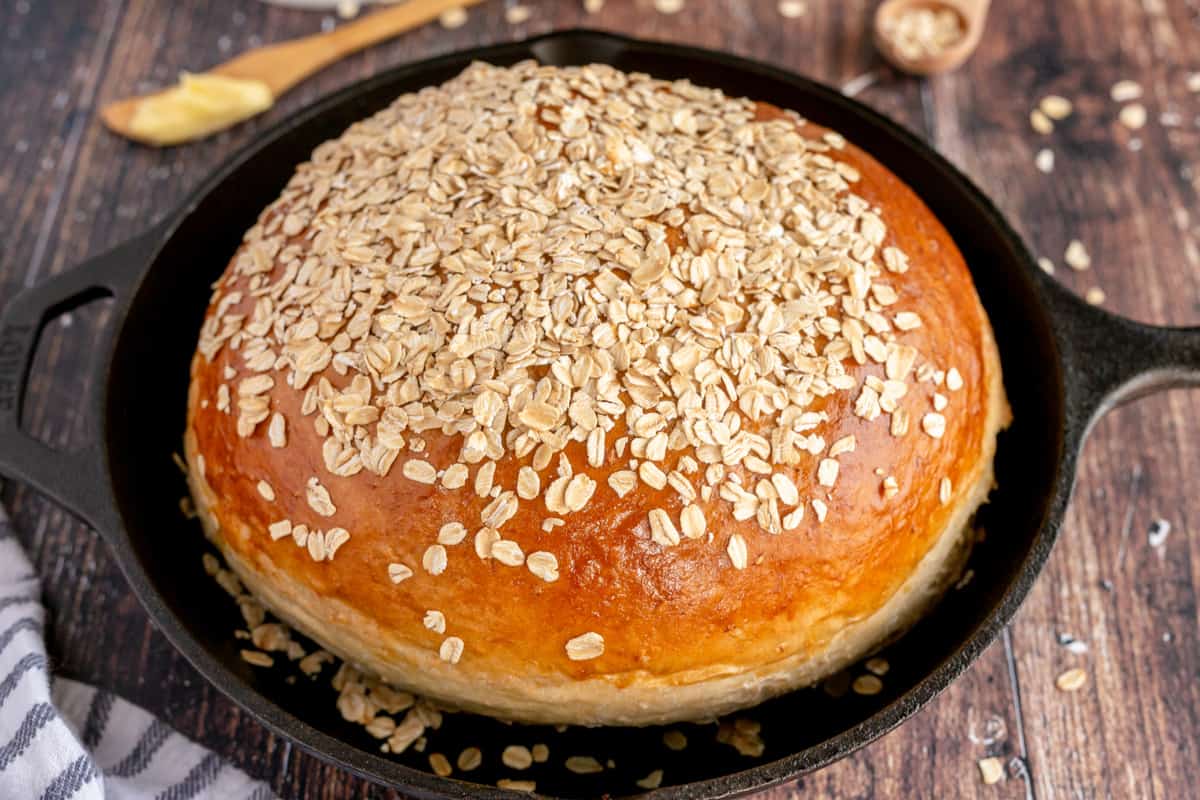 loaf of oatmeal bread in a cast iron skillet