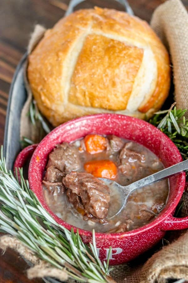 beef stew in a red bowl with bread