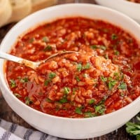 tomato rice soup in a white bowl with bread