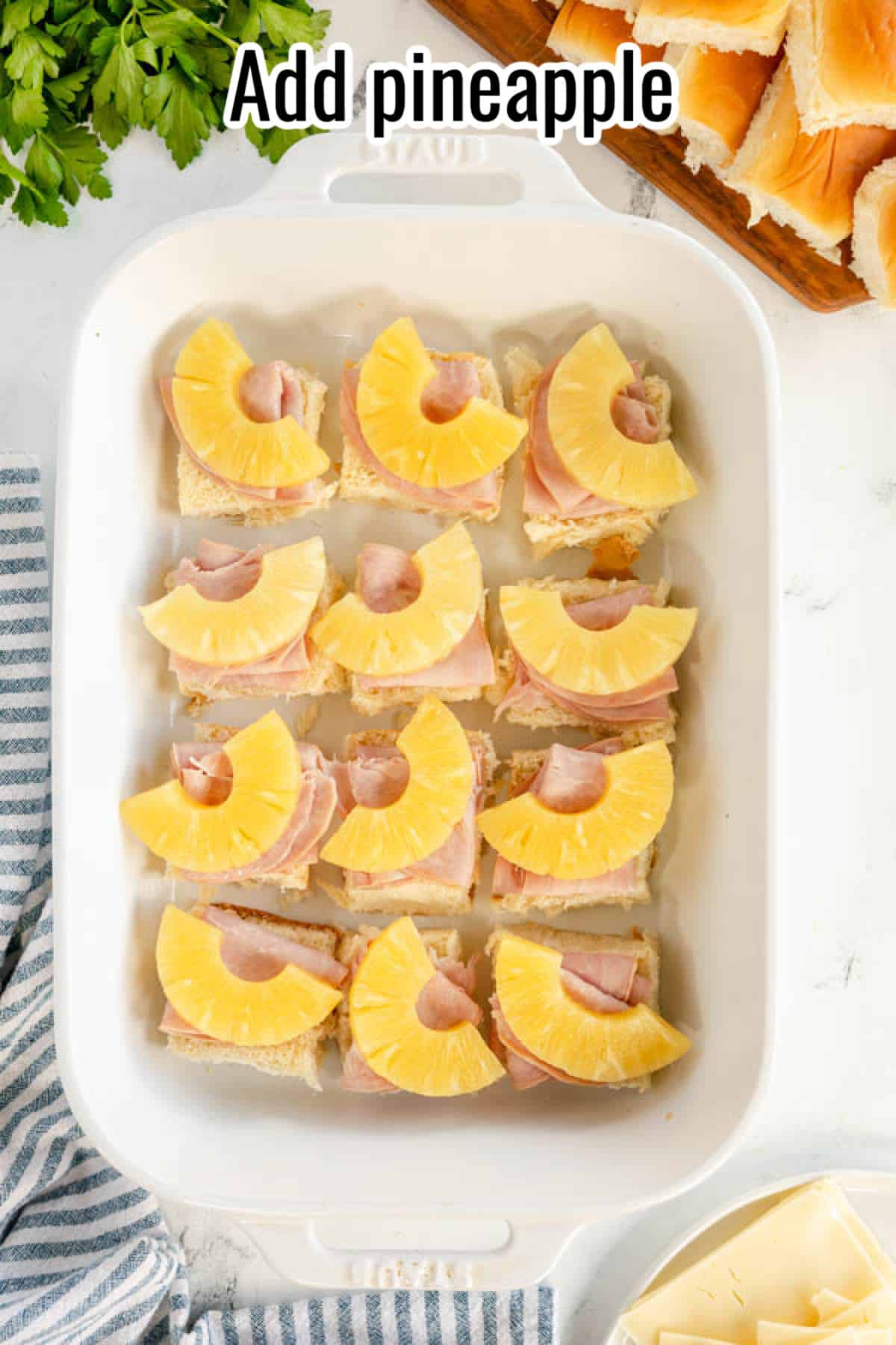 A white dish with ham and pineapple in it, perfect for a delightful twist on traditional ham and cheese sliders.