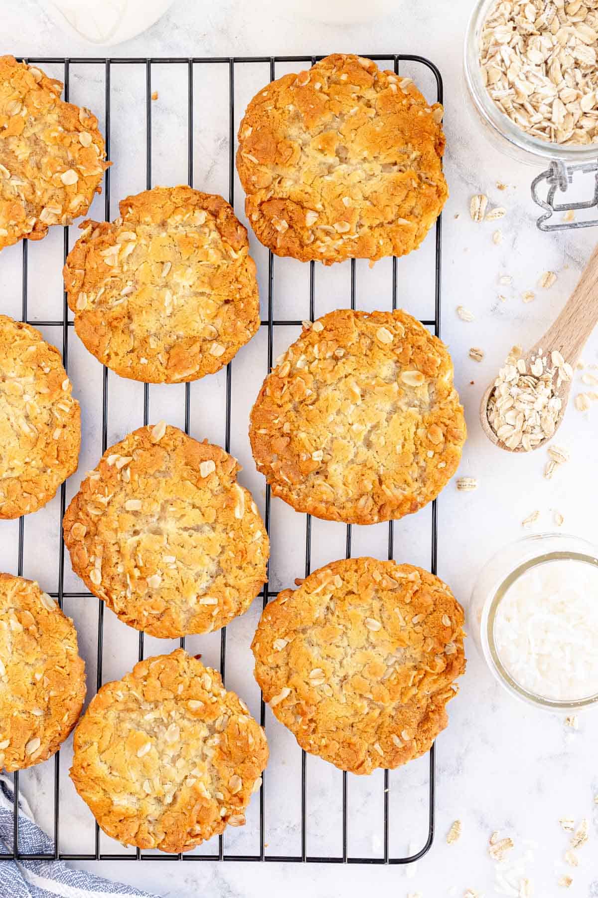 fully baked anzac biscuits on a wire rack.