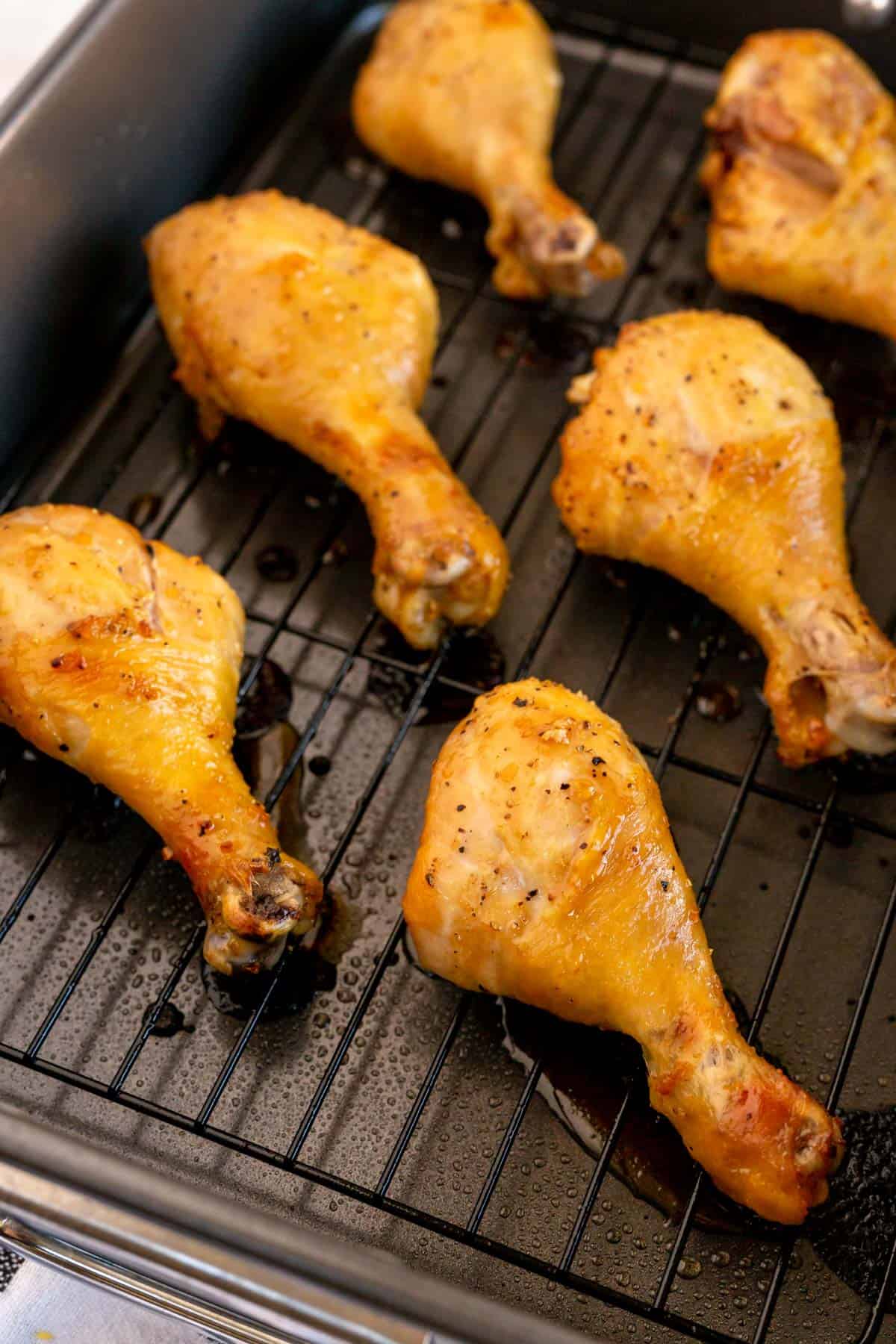 roasted chicken drumsticks in a black roasting dish