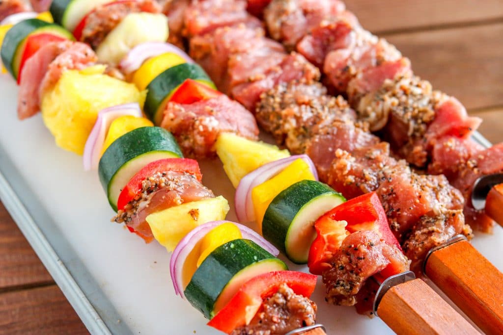 uncooked pork kabobs on a cutting board