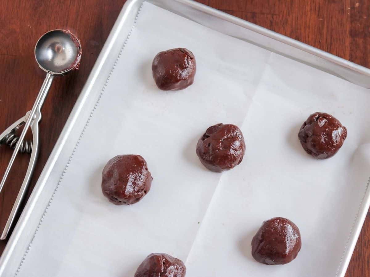 balls of cookie dough on a parchment lined baking sheet
