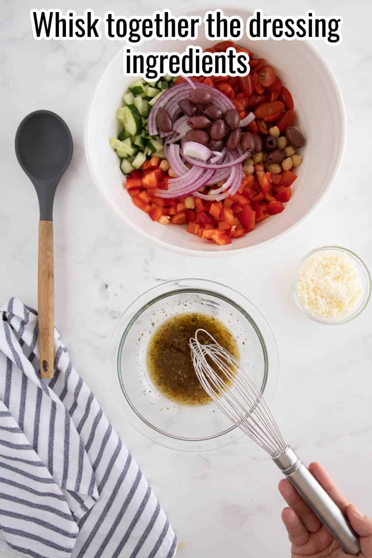 Bowl with salad ingredients, a spoon and another bowl with dressing being whisked together.