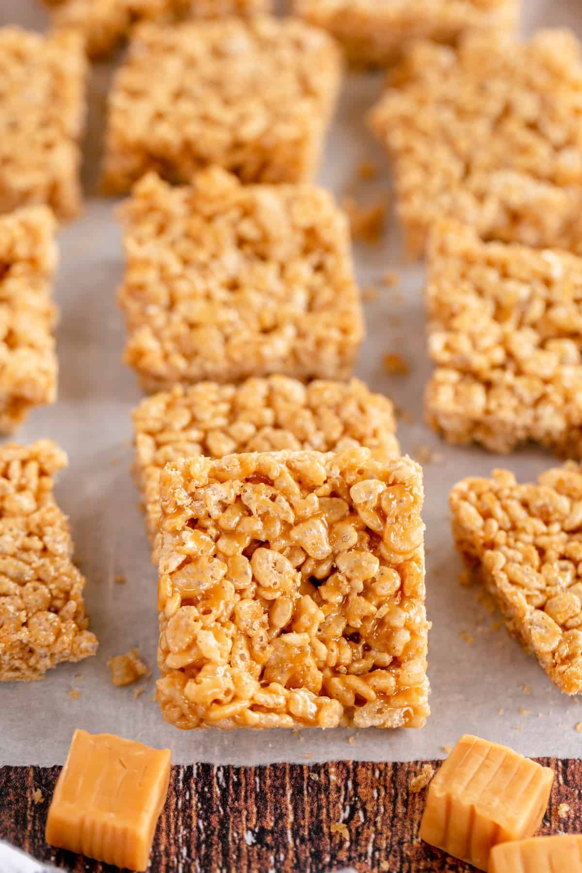 caramel rice krispie treats on parchment with caramel candies