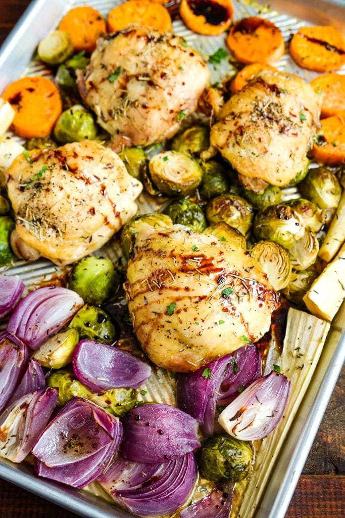 Roast chicken thighs and vegetables on baking sheet.