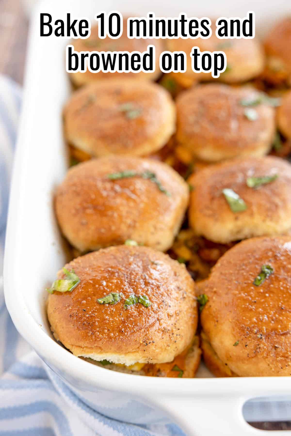 baked sliders in a white baking dish.