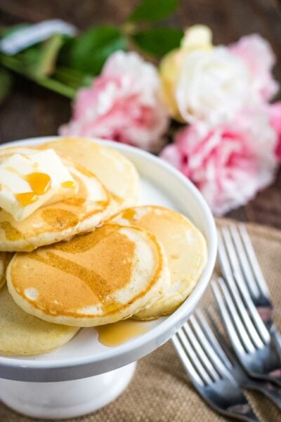 stack of homemade pancakes with forks and pink flowers