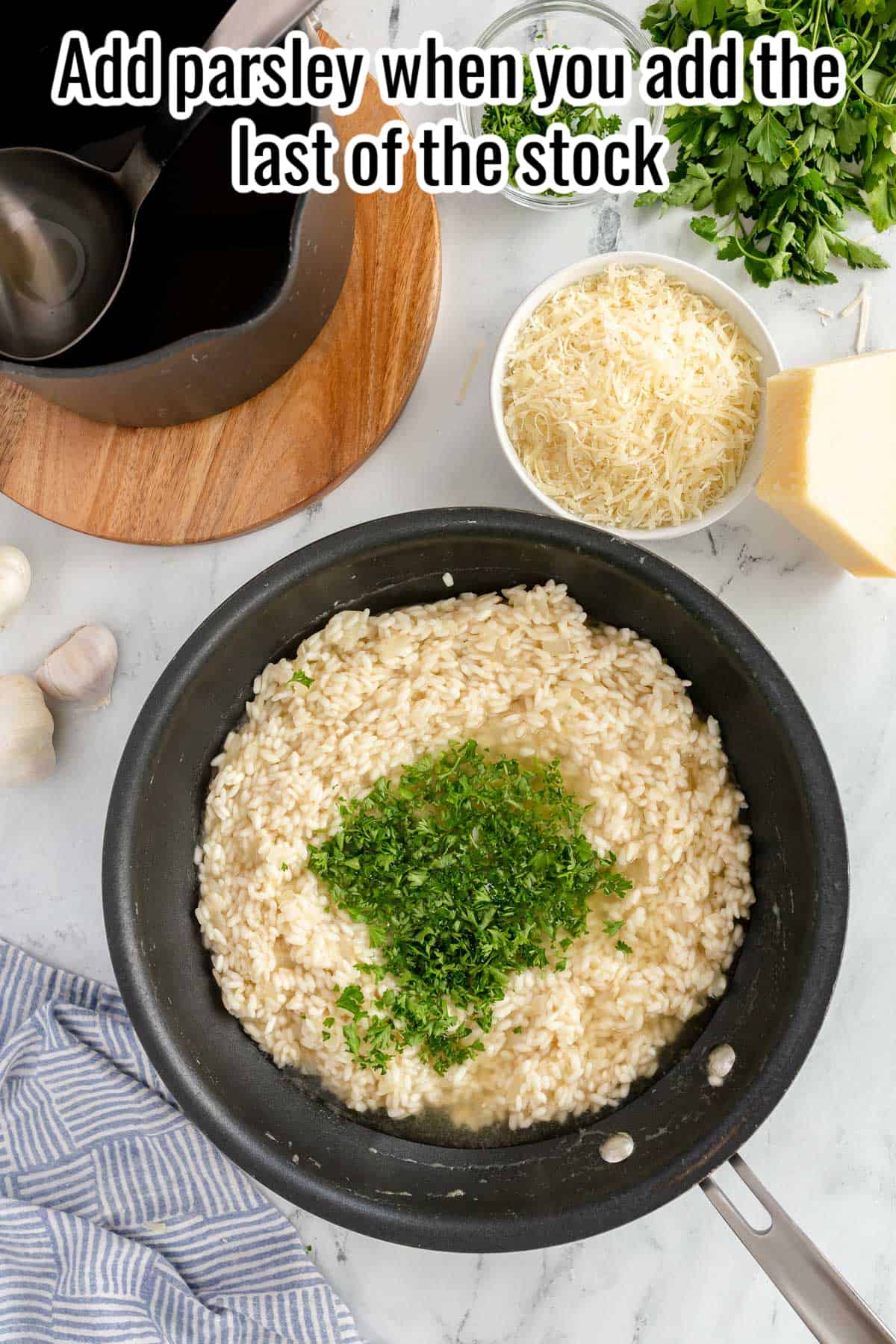 a black skillet with risotto and chopped parsley over the top.