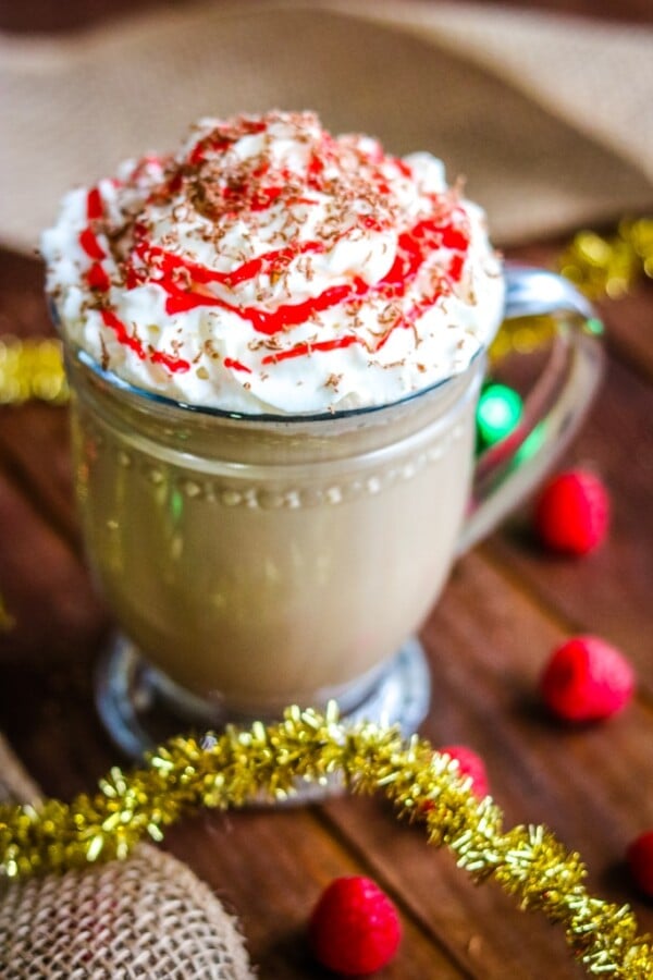raspberry mocha latte in a glass cup with christmas decorations