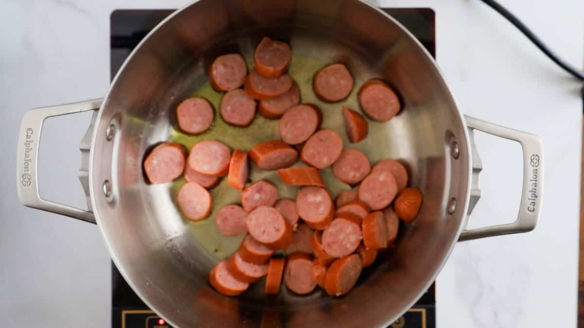 a skillet with sliced sausage in it.