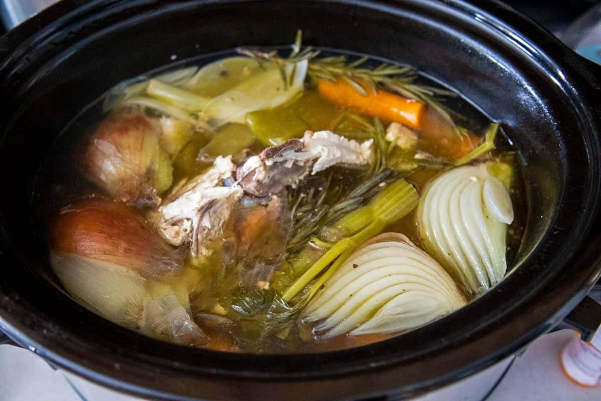 fully cooked chicken stock in a black crockpot